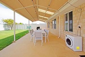 a patio with a table and chairs and a washing machine at Fishface Retreat in Jurien Bay