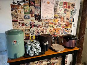 a shelf with a coffee maker and a wall of photos at Faire BNB Homestay in Timuran