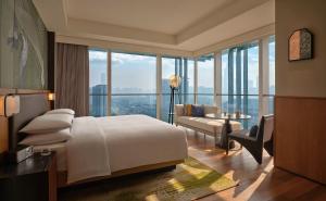 a bedroom with a large bed and a living room at Hyatt Centric Gaoxin Xi'An in Xi'an