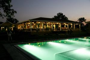 een gebouw met verlichting naast een zwembad in de nacht bij Anaya Resort in Kota