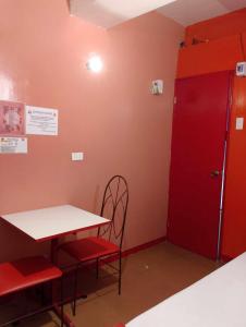 a room with a table and chairs and a red door at WJV INN PALAWAN in Puerto Princesa City