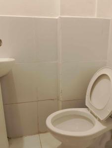 a bathroom with a white toilet and a sink at WJV INN PALAWAN in Puerto Princesa City