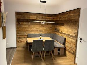 ein Esszimmer mit einer Holzwand sowie einem Tisch und Stühlen in der Unterkunft AAA FeWo Bad Gastein/Böckstein in Bad Gastein