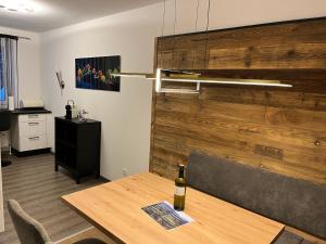 a dining room with a table with a bottle of wine at AAA FeWo Bad Gastein/Böckstein in Bad Gastein