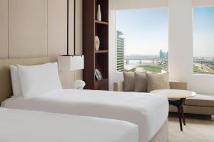 انتركونتيننتال دبي فيستيفال سيتي في دبي: غرفة نوم بسرير ابيض واريكة ونافذة