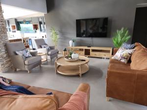 a living room with couches and a flat screen tv at Highland gate Golf estate Mountain view 780 in Dullstroom