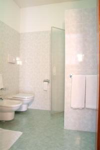 a bathroom with a toilet and a sink and a shower at Hotel Alla Dolina in Sistiana