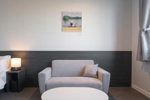 una sala de estar con una silla y una foto en la pared en Workers Hotel Daejeon by Aank en Daejeon