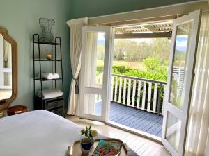 a bedroom with a door open to a porch with a deck at Exhale at Millfield Homestead in Millfield