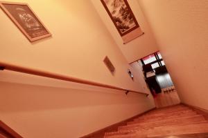 a hallway with stairs and pictures on the wall at Osaka Umeda Yuan Hostel in Osaka