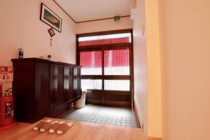 a living room with a door and a table with slippers at Osaka Umeda Yuan Hostel in Osaka