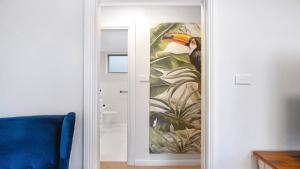 a painting of a bird on a wall next to a door at Summer By The Sea Umina Beach in Ettalong Beach