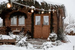 a log cabin with a door in the snow at Ambercoast in Jūrmala