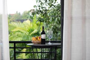 a bottle of wine and a basket of fruit on a table at Madam Sokha Homesteading in Siem Reap