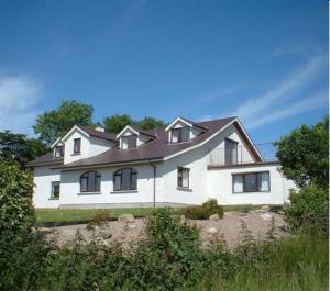 een groot wit huis bovenop een heuvel bij Golden Hill Guest House in Omagh