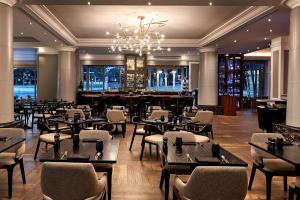 a restaurant with tables and chairs and a chandelier at Brisbane Marriott Hotel in Brisbane