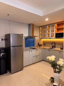 eine Küche mit einem Kühlschrank und Schränken aus Edelstahl in der Unterkunft Pejaten Park Residence in Jakarta