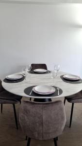 - une table avec des assiettes et des verres à vin dans l'établissement Appart'Chic, à Paris