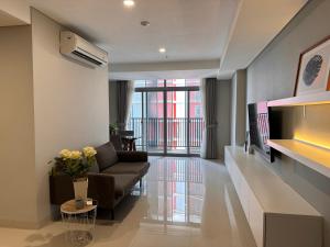 a living room with a couch and a tv at Pejaten Park Residence in Jakarta