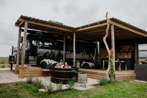 zwei Personen sitzen in einem Whirlpool unter einem Bus in der Unterkunft Libertas Guest Farm in Hoekwil