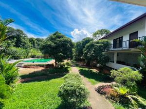 a garden view of a house and a swimming pool at Sigiriya Sun Shine Villa in Sigiriya