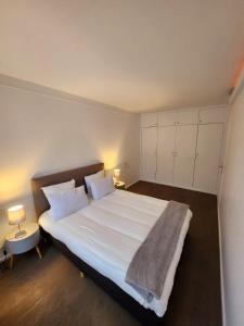 een slaapkamer met een groot wit bed met 2 kussens bij Appart'Chic in Parijs