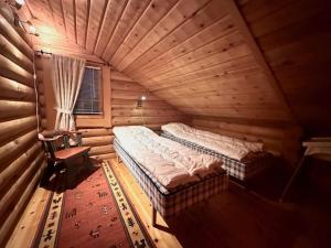 Habitación con 2 camas en una cabaña de madera en Villa Tsahkal Kilpisjärvi en Kilpisjärvi