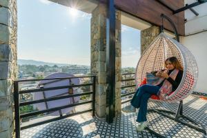 a woman sitting in a hammock looking at her cell phone at ArtBuzz Dehradun in Dehradun