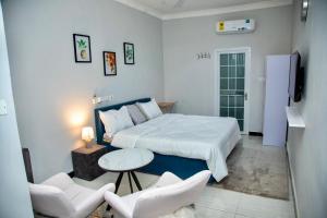 1 dormitorio con 1 cama, mesa y sillas en BryMac Hotel en Koforidua