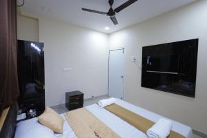 um quarto com uma cama e uma televisão de ecrã plano em Hotel SolStay Inn Residency em Thane