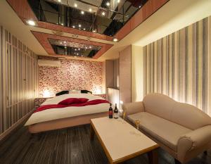 1 dormitorio con 1 cama y 1 sofá en Hotel Jardin de Fleurs (Adult Only), en Kioto