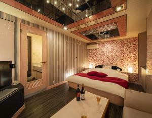 京都市にあるジャルダンフルール(大人専用)のベッドルーム(ベッド1台、ソファ、テレビ付)