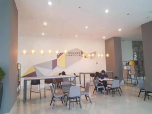 a group of people sitting at tables in a room at Apartement orchard Surabaya in Surabaya