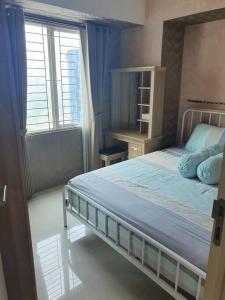 um quarto com uma cama grande e uma janela em Apartement orchard Surabaya em Surabaya