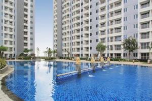 a large swimming pool in front of two tall buildings at Apartement orchard Surabaya in Surabaya