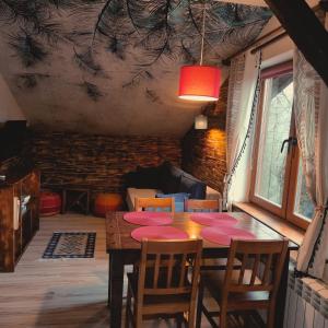 a dining room with a wooden table and chairs at Ostoja nad potokiem Dwernik in Dwernik