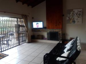 a living room with a couch and a television at Salt Life in Port Shepstone