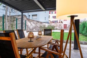 a wooden table with two lamps on a patio at Appartement Cosy Jardin et Terrasse in Strasbourg