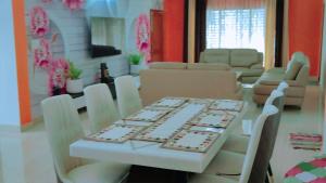 uma sala de jantar com uma mesa e cadeiras brancas em The ROI Palace em Faridabad