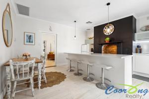 cocina con barra y mesa con sillas en Hyde Cottage, en Meningie