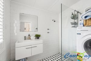 a white bathroom with a sink and a washing machine at Hyde Cottage in Meningie
