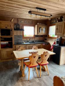 a kitchen with a wooden table and two chairs at l'écureuil in Saint-Laurent-en-Grandvaux