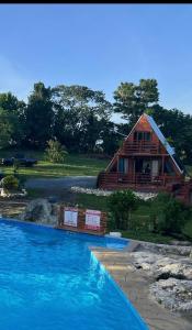 um chalé de madeira com uma piscina em frente em Cabaña 787 em Lares