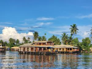 a group of boats traveling down a river at sacred river homestay in Alleppey