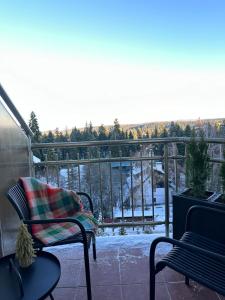 a chair sitting on a balcony with snow on the ground at Sana Ski apartment 702 in Flora, Borovets in Borovets