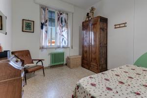 Casa Rosanna في فلورنسا: غرفة نوم بسرير وخزانة وكرسي