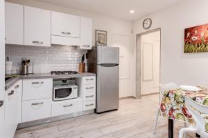 een keuken met witte kasten en een roestvrijstalen koelkast bij Oltrarno Dreaming in Florence