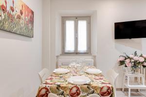 een witte eetkamer met een tafel en bloemen bij Oltrarno Dreaming in Florence