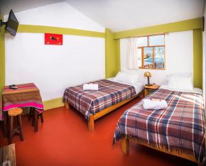 Pokój z 2 łóżkami, stołem i oknem w obiekcie Sumaq Wayra w mieście Yanque