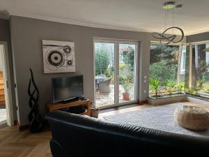 a living room with a couch and a television at Entspannung am Niederrhein - großes helles Haus mit Kamin in Emmerich